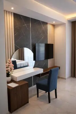 a bedroom with a desk and a tv on a wall at Hotel Adler in Ulcinj
