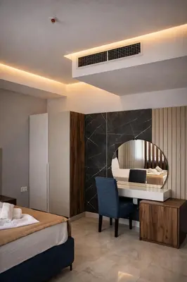 a hotel room with a bed and a desk and a piano at Hotel Adler in Ulcinj