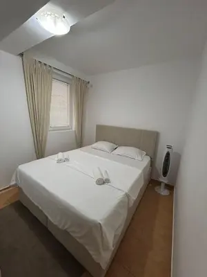 a bedroom with a large white bed with a window at Apartment Elena in Prijevor
