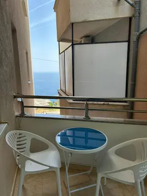 a table and chairs on a balcony with a view of the ocean at Apartment Elena in Prijevor