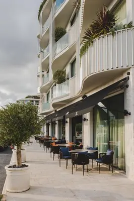 a row of tables and chairs in front of a building at Luminoso Boutique Hotel in Budva