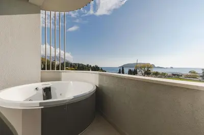 a bathroom with a tub and a view of the ocean at Luminoso Boutique Hotel in Budva