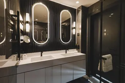a bathroom with three sinks and three mirrors at Luminoso Boutique Hotel in Budva