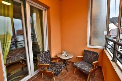 a balcony with two chairs and a table and a window at Apartment Sole in Cetinje