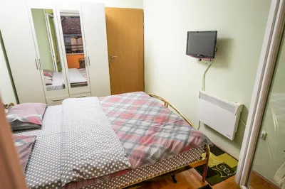 a small room with a bed and a tv on the wall at Apartment Sole in Cetinje