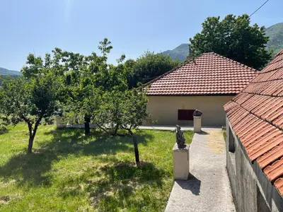 a garden with trees and a building with a fence at The Viewpoint House - Njeguši in Njeguši