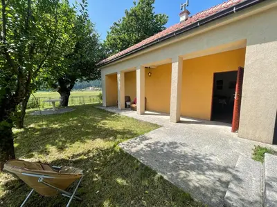 a building with a yard with a chair in the grass at The Viewpoint House - Njeguši in Njeguši
