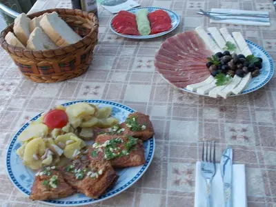 a table topped with plates of food with toast and fruit at Guesthouse Feel Lake in Virpazar