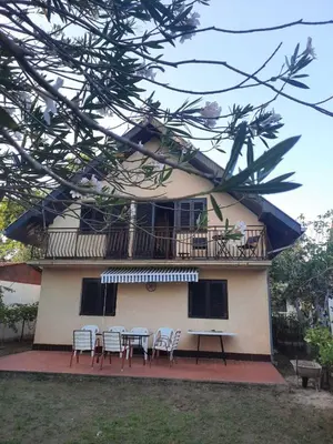 a house with a balcony and a table and chairs at Apartman Nina in Donji Štoj
