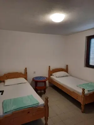 a room with two beds and a table at Apartman Nina in Donji Štoj