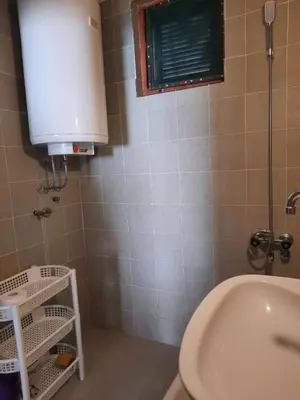 a bathroom with a toilet and a sink and a window at Apartman Nina in Donji Štoj