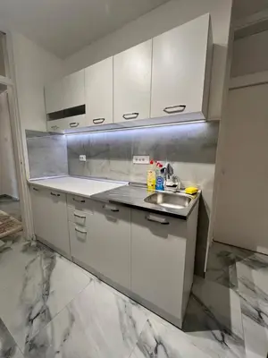 a kitchen with white cabinets and a sink at Apartment Zeneli in Ulcinj