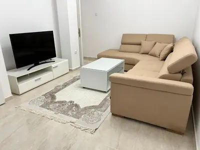 a living room with a couch and a flat screen tv at Apartment Zeneli in Ulcinj