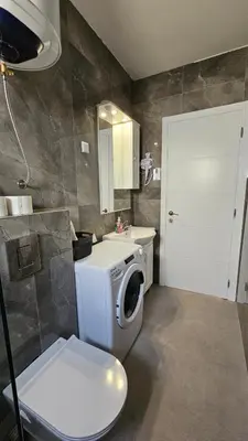 a bathroom with a toilet and a washing machine at ValMar in Bar, Susanj