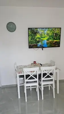a white table and chairs with a tv on the wall at ValMar in Bar, Susanj