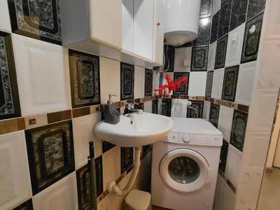 a bathroom with a sink and a washing machine at Black Cat Apartment in Budva