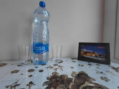 a bottle of water sitting on a table with glasses at Black Cat Apartment in Budva