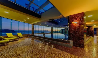 a lobby with chairs and a pool in a building at Apartment TC Lux VLSB in Budva