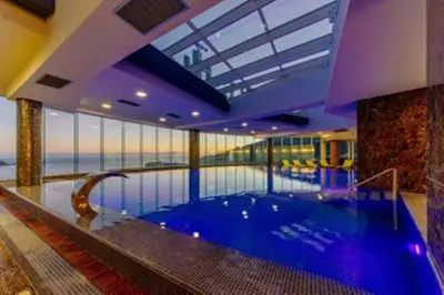 a large swimming pool in a building with a large window at Apartment TC Lux VLSB in Budva