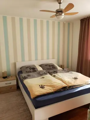 a bedroom with a bed with striped walls and a ceiling at Уютная 1-комнатная квартира с видом на море! in Bar