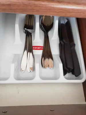 four utensils in a drawer in a cabinet at Уютная 1-комнатная квартира с видом на море! in Bar