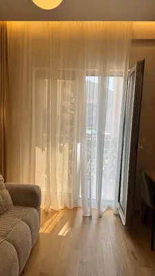a living room with a couch and a large window at Studio 7-Budva in Budva