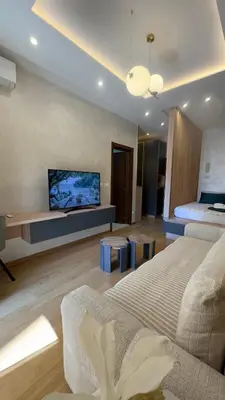 a living room with a bed and a flat screen tv at Studio 7-Budva in Budva