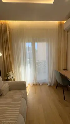 a living room with a couch and a large window at Studio 7-Budva in Budva