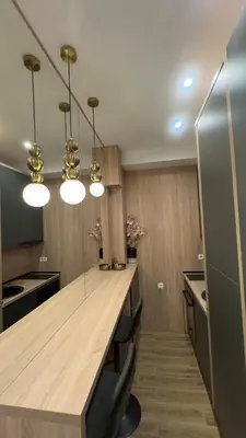 a kitchen with a large wooden counter with lights at Studio 7-Budva in Budva