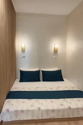 a bed in a room with two blue pillows at Studio 7-Budva in Budva