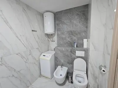 a white bathroom with a toilet and a sink at Green Stone lamela B in Rafailovici