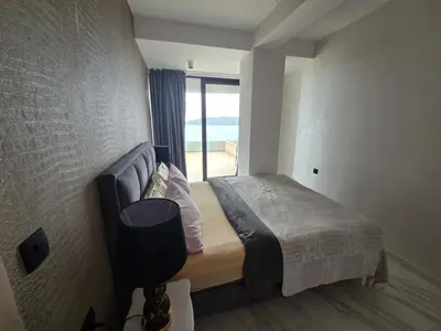 a bedroom with a bed and a large window at Green Stone lamela B in Rafailovici