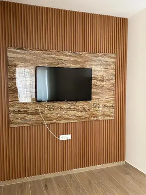 a flat screen tv hanging on a wall at Green Stone lamela B in Rafailovici