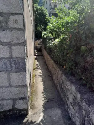 an alley with a brick wall and some bushes at Apartment Lima in Kotor