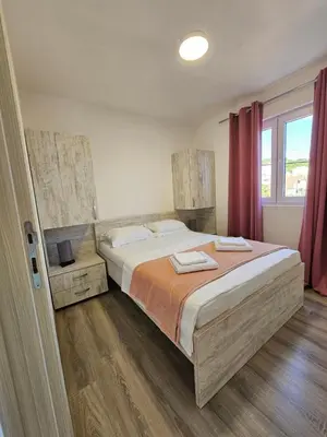 a bedroom with a large bed with red curtains at Open Sky Montenegro in Utjeha