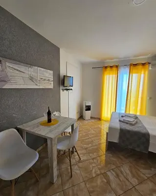 a room with a table and chairs and a bed at Open Sky Montenegro in Utjeha