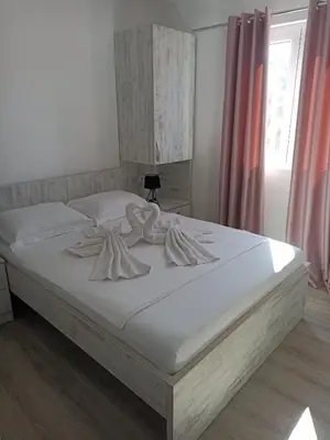 a bedroom with a bed with white sheets at Open Sky Montenegro in Utjeha