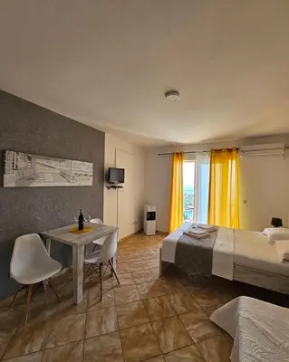 a hotel room with a bed and a table and chairs at Open Sky Montenegro in Utjeha