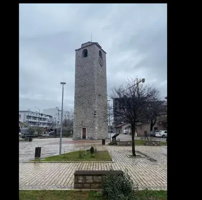 a tall tower with a clock on it in a park at Tip top downtown in Podgorica