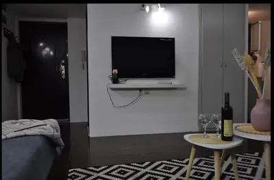 a living room with a tv on a white wall at Tip top downtown in Podgorica