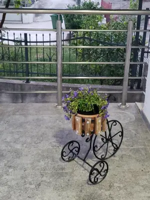 a flower pot on a cart with purple flowers at Первая аренда уютного дома для летнего отдыха in Kravlja