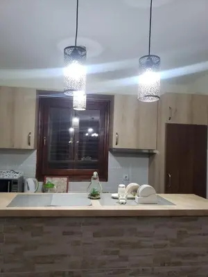 a kitchen with two lights hanging over a kitchen counter at Первая аренда уютного дома для летнего отдыха in Kravlja