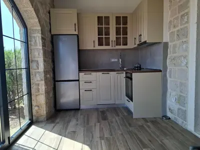 a kitchen with white appliances and a brick wall at Tamape apartment in Katun