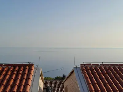 a view of the ocean from the roofs of two buildings at Tamape apartment in Katun