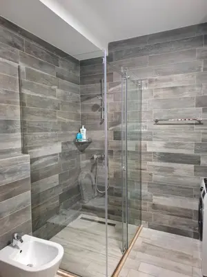 a bathroom with a glass shower and a sink at Tamape apartment in Katun
