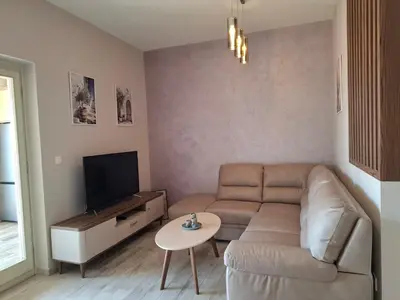 a living room with a couch and a tv at Tamape apartment in Katun