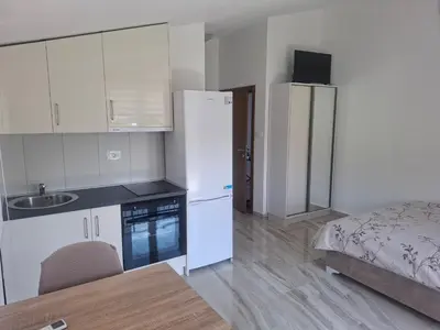 a kitchen with a white refrigerator and a bed at Apartman Andjela 3 in Lastva