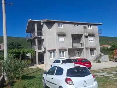 a white car parked in front of a building at Apartman Andjela 3 in Lastva