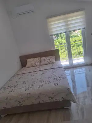 a bedroom with a bed with a large window at Apartman Andjela 3 in Lastva