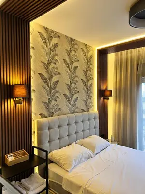 a bedroom with a bed and a wall with a flower mural at Montenegro Prestige Suite in Podgorica